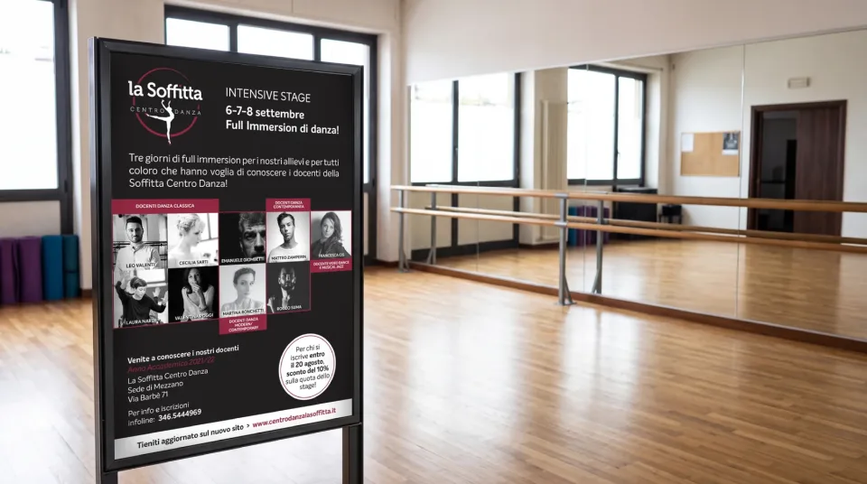 Locandina dello stage intensivo di settembre su un cavalletto in una sala di danza: logo, date, la griglia con i docenti di danza classica e contemporanea e lo sconto per chi si iscrive entro il 20 agosto