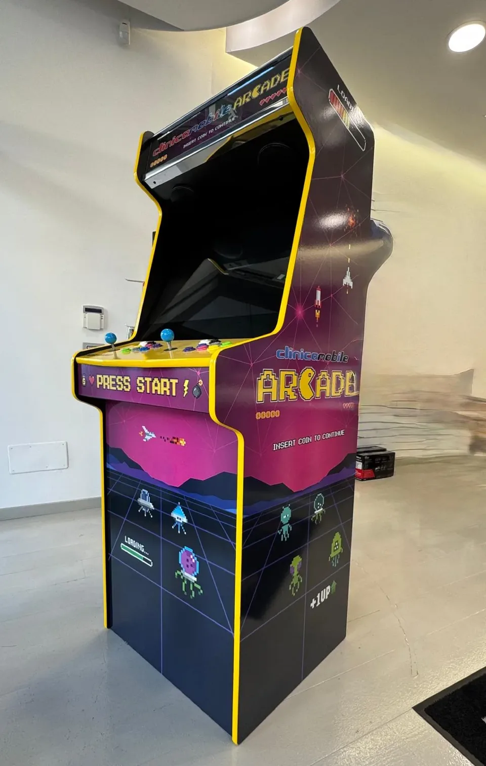 Il fianco sagomato del cabinet, con la barra Loading, le astronavi e la scritta clinicamobile Arcade