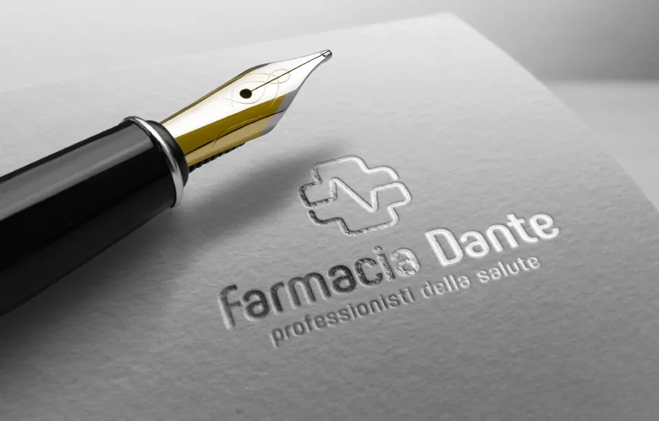 Il marchio Farmacia Dante impresso a secco su carta grigia, accanto a una penna stilografica