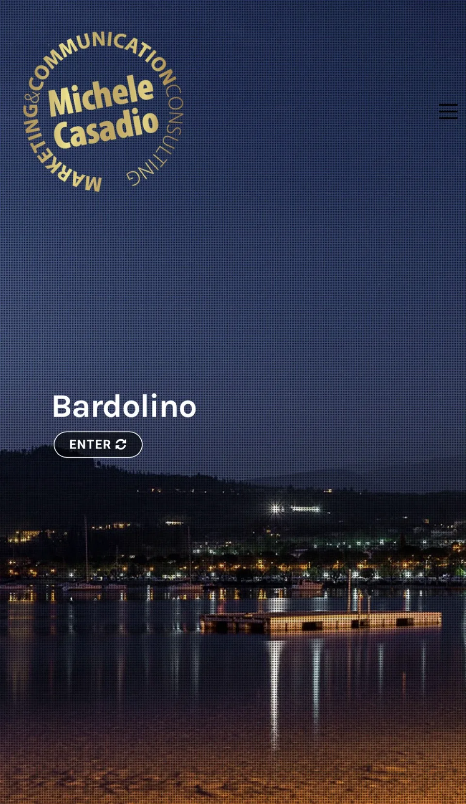 La home del sito su telefono: il marchio d’oro sopra una foto notturna del lago a Bardolino